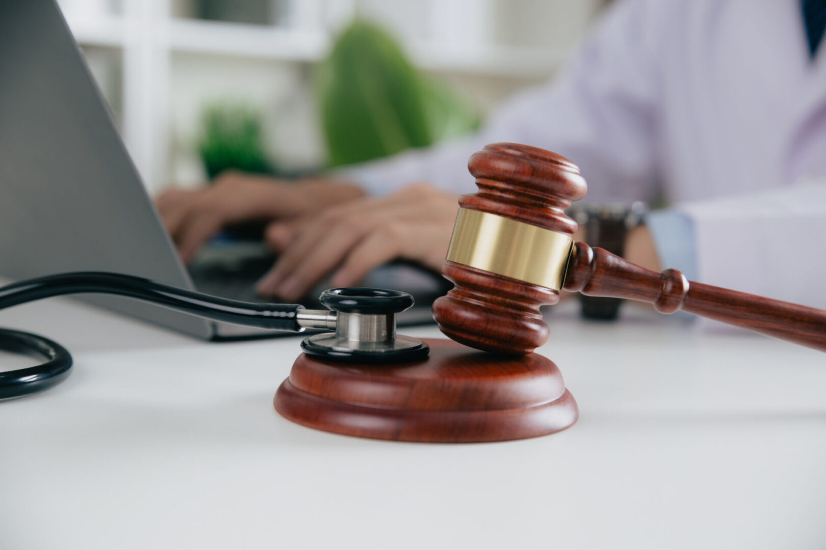 Judge's gavel beside stethoscope and laptop